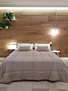 莫诺波利Allo Zefiro的一间卧室设有一张带木墙的大床