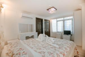 安塔利亚庭院酒店的白色卧室设有一张大床和电视。