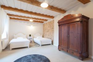 KalnmuižaKalnmuižas pils的一间带两张床和大型木制橱柜的卧室