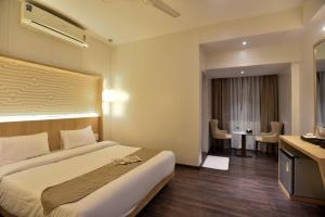 孟买The Aarya的酒店客房设有一张大床和一张书桌。