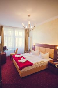 莱比锡Hotel Arena City的酒店客房设有一张带红色毯子的大床