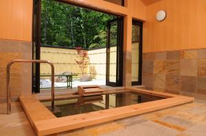 白马村罗格小屋大纪元酒店的窗户客房中间的热水浴池