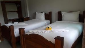 班武里府Suksopha Resort的两张带白色床单和南瓜的床