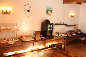 卡斯特尔诺-德蒙特米尔德斯康索斯酒店的一间房间,墙上挂着一张桌子和食物,还有时钟