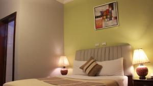 亚的斯亚贝巴半边莲酒店的一间卧室配有一张带两盏灯的床。