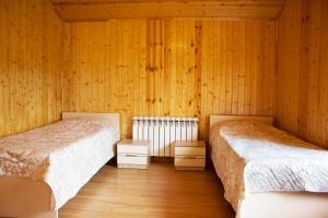 库萨雷Villa Premium Qusar的配有木墙和木地板的客房中的两张床
