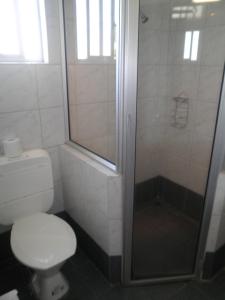 南迪魔蝎座国际酒店的一间带卫生间和玻璃淋浴间的浴室