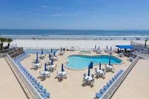 德通纳海滩海岸Sea Club IV Resort的一个带游泳池和椅子的海滩和大海