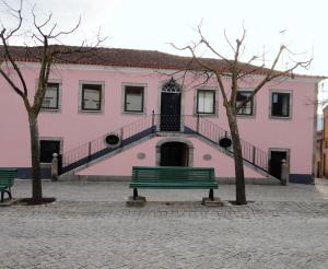 LajeosaCasa do Brigadeiro的粉红色的建筑,前面有长凳