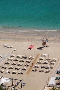 贝尔杰吉Hotel Claudio的海滩上放着一堆椅子和一匹马