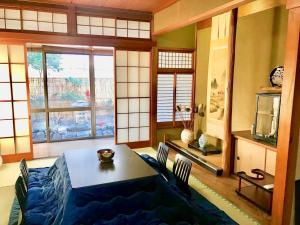 京都京都岚山宾馆的一间带桌椅和窗户的用餐室