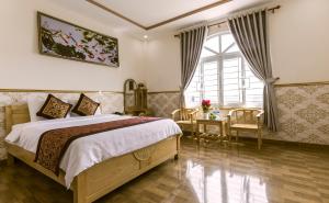 邦美蜀AEC班米酒店的一间卧室设有一张大床和一个窗户。