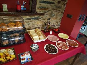 SobradoHotel Rural Pescadores的一张桌子,上面有红色的桌布,上面有不同类型的食物