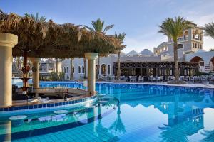 赫尔格达伊贝罗泰尔马卡迪海滩酒店的棕榈树度假村的游泳池