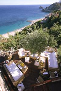 贝尔杰吉Hotel Claudio的一个带桌椅的甲板和海滩