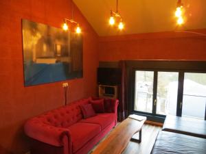 Marcouray卢兹度假屋的客厅配有红色沙发和电视