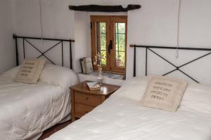 比拉法梅斯L'Arc de Pedra的一间卧室设有两张床和一张木桌