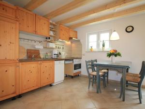 施特芬斯哈根Modern Holiday Home in Steffenshagen with Terrace的厨房配有木制橱柜和桌椅