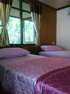 库德岛Koh Kood Little Hut的一间卧室设有两张床和窗户。