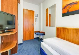 斯图加特佛力登斯广场酒店的配有一张床和一台平面电视的酒店客房