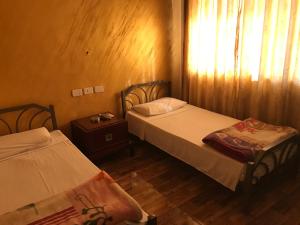安曼Sun Rise Hotel & Hostel & Tours的一间卧室设有两张床,窗户配有窗帘