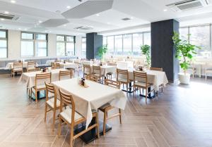 尼崎市阪神神崎前根Y‘s酒店的用餐室设有桌椅和窗户。