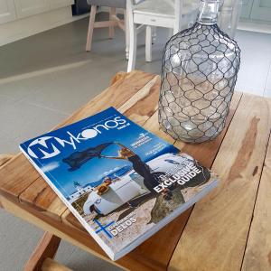 阿诺梅拉Antheia Suite of Mykonos的木桌上摆着的杂志
