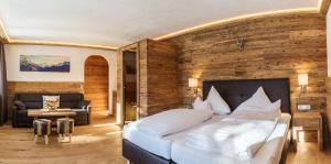 蒂罗尔-基希贝格Almhof Kitzlodge - Alpine Lifestyle Hotel的一间卧室设有一张带木墙的大床