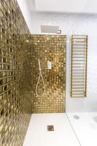 萨莱诺Civico Cinque Home Luxury Apartment的带淋浴的浴室和金色瓷砖墙