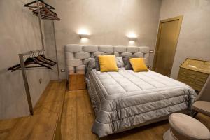 萨莱诺Civico Cinque Home Luxury Apartment的一间卧室配有一张带黄色枕头的大床