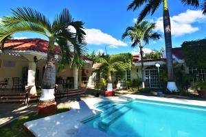 坎昆坎昆图里潘斯别墅的棕榈树屋前的游泳池