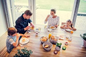 卡斯特尔莱德沙普斯科伊农家乐的坐在桌子旁吃早饭的家庭