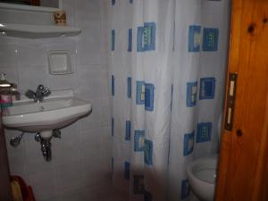 阿提蒙巴提卡客房公寓的一间带水槽和淋浴帘的浴室