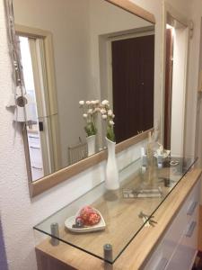 格拉茨Komfortables Appartement/Garconniere in Graz für Urlaub und Geschäftsreisen的一张桌子,上面有镜子和一盘花