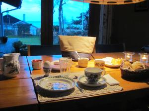 赫尔辛厄提丝维尔德艮班德布住宿加早餐旅馆的一张木桌,上面有盘子和杯子