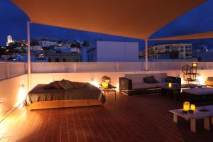 伊维萨镇胡安妮塔旅馆的卧室在晚上在阳台上配有一张床