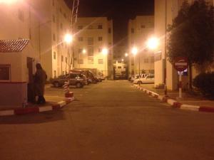 Douar Ben ChellalCozy Appartement的夜间在停车场停车的街道