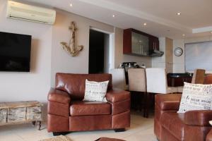 莫塞尔湾Seafront Apartment in Mossel Bay的客厅配有沙发和椅子