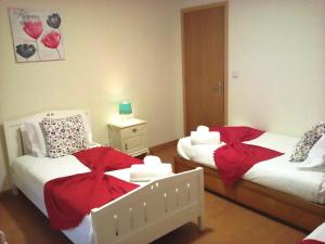 加亚新城Portus Ribeira House的一间卧室配有两张红色弓床