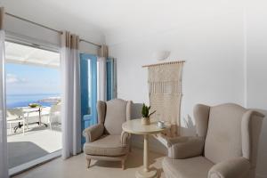 易莫洛林仙女座别墅度假酒店的一间带桌椅的客厅和一个阳台