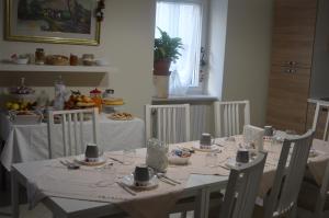 阿尔塔穆拉B&B La Colomba的一间用餐室,配有白色的桌子和白色的椅子