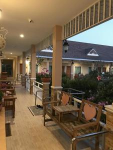 班武里府Suksopha Resort的一座配有长椅和桌子的庭院以及一座建筑
