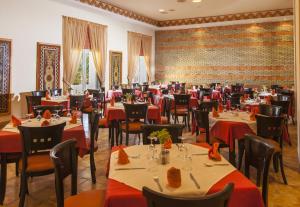 杜兹撒哈拉杜兹酒店的餐厅配有桌椅和红色桌布
