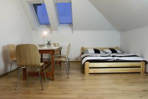 霍多宁Apartmány za sakurou的卧室配有一张床和一张桌子及椅子