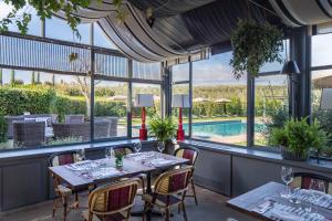 卡帕尔比奥洛坎达罗萨酒店的一间带桌椅的用餐室和一个游泳池
