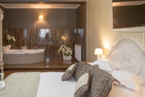 索哈切夫肖邦酒店的一间卧室配有浴缸和一张带枕头的床。