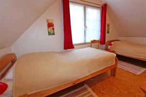 NeuhausFerienhaus Dierhagen MOST 891的一间卧室配有一张带红色窗帘的床和一扇窗户