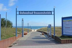 特拉森海德Ferienhaus Trassenheide USE 2852的通往海滩的步行道,上面标有读到十二指肠的标志