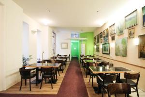 柏林萨科森霍夫酒店的一间带桌椅的用餐室和一扇绿门