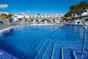 卡门港Relaxia Lanzaplaya的一个大型蓝色游泳池,酒店背景